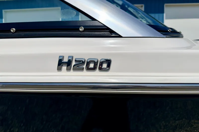 Slide: The Image of 2014 Four Winns H200 boat emblem on sleek white exterior. - 11