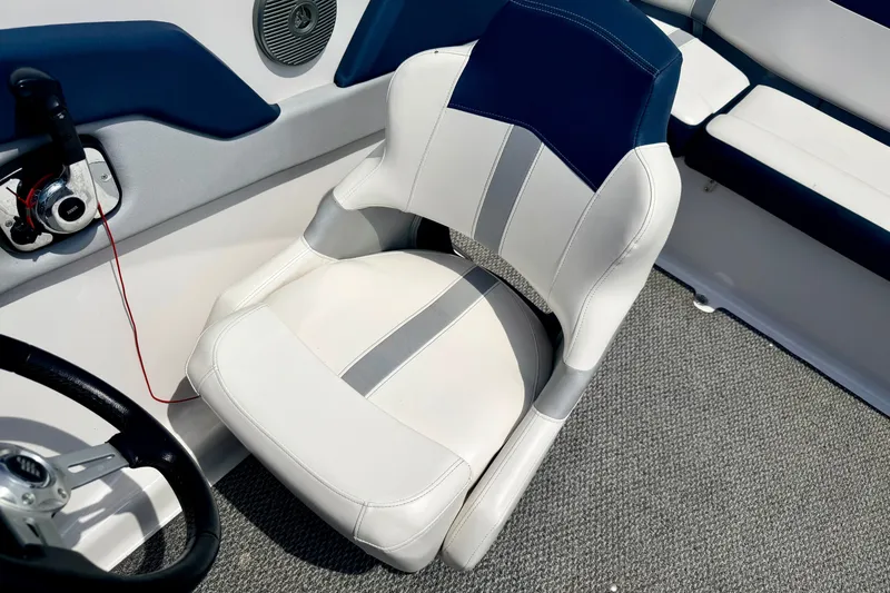 Slide: The Image of Captain's seat in a 2014 Four Winns H200 boat, featuring white and blue upholstery. - 61
