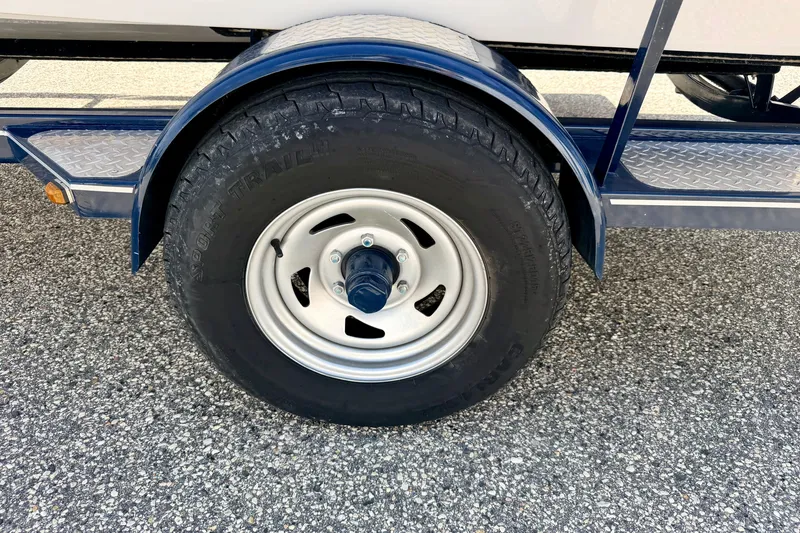 Slide: The Image of Trailer wheel of a 2014 Four Winns H200 boat on textured pavement. - 88