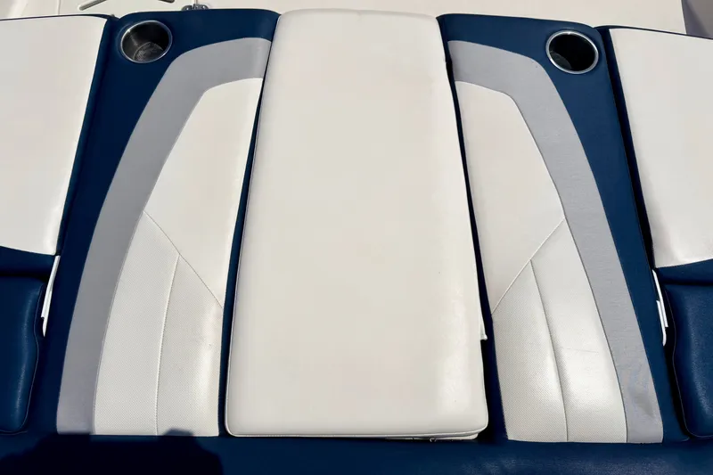 Slide: The Image of 2014 Four Winns H200 boat seating with white and blue upholstery, featuring cup holders. - 79