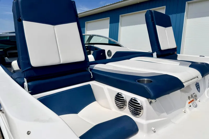 Slide: The Image of 2014 Four Winns H200 boat interior with blue and white seating, cup holders, and speakers. - 22