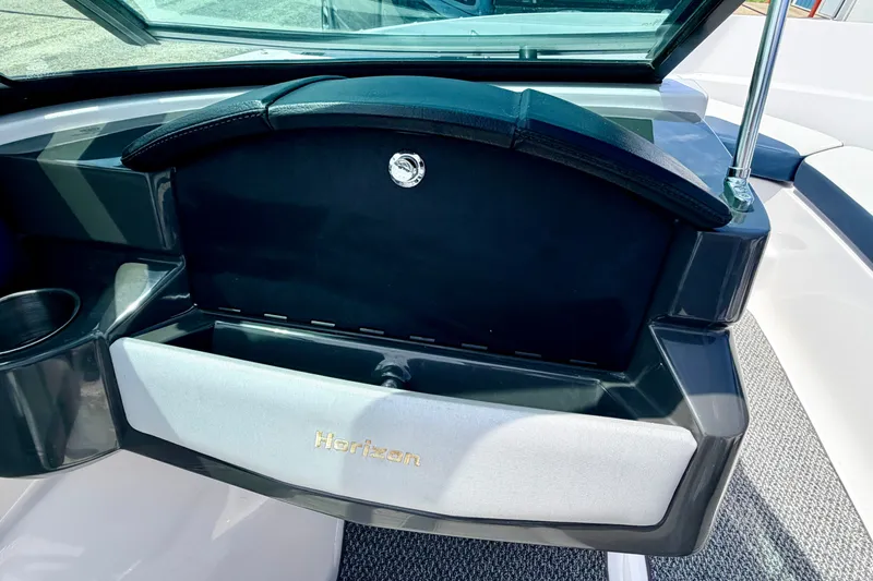 Slide: The Image of 2014 Four Winns H200 boat dashboard with storage compartment and cup holder. - 46