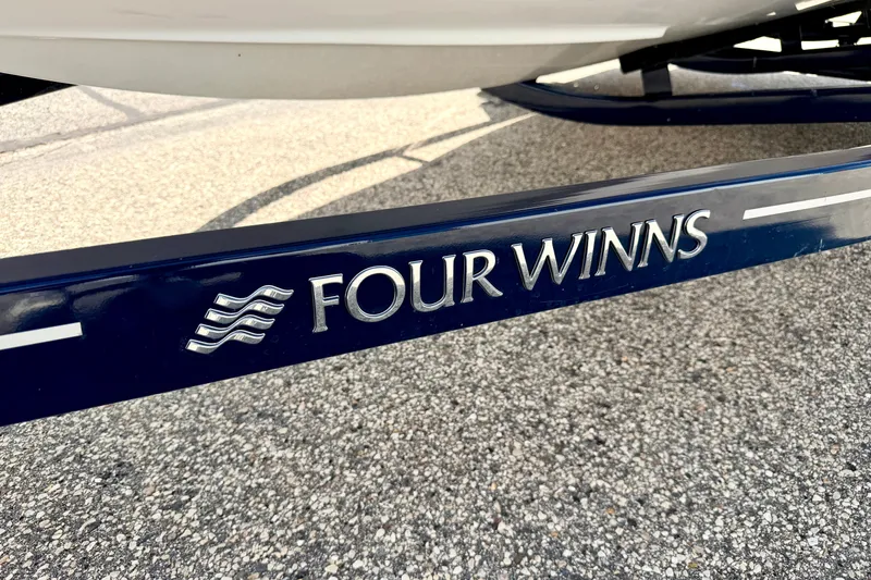 Slide: The Image of 2014 Four Winns H200 boat trailer with logo on pavement background. - 89