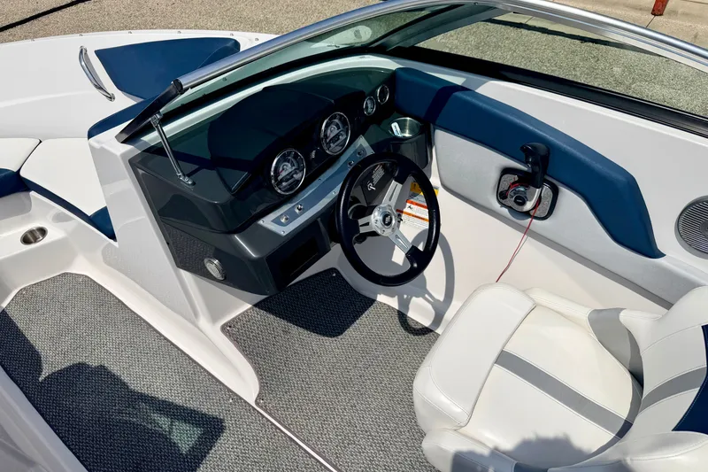 Slide: The Image of 2014 Four Winns H200 boat interior with steering wheel and dashboard controls. - 78
