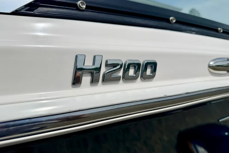 Slide: The Image of Close-up of 2014 Four Winns H200 boat emblem on white surface. - 15