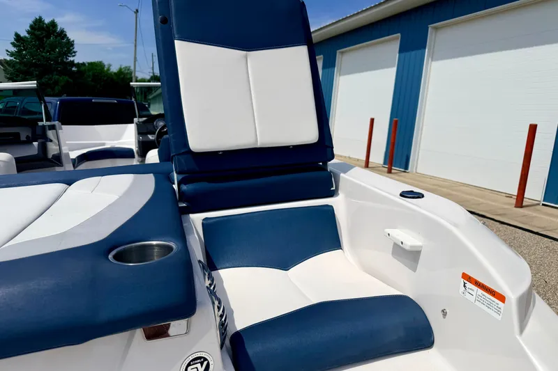 Slide: The Image of 2014 Four Winns H200 boat interior with blue and white seating, cup holder, and storage compartment. - 23