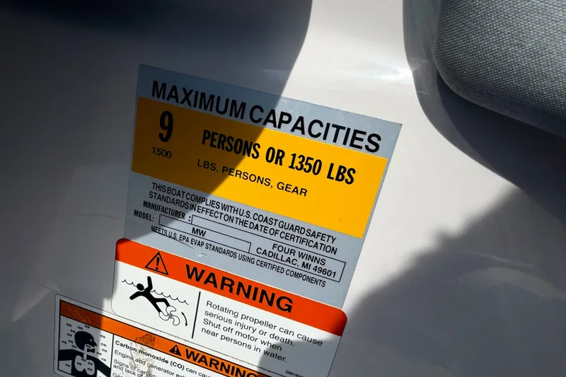 Slide: The Image of 2014 Four Winns H200 capacity label, maximum 9 persons or 1350 lbs, safety warnings included. - 58