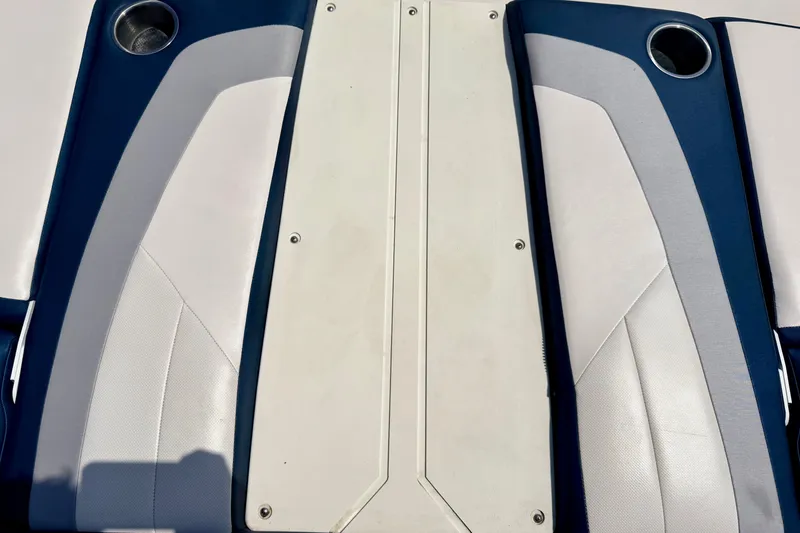 Slide: The Image of 2014 Four Winns H200 boat seating with cup holders, featuring white and blue upholstery. - 80