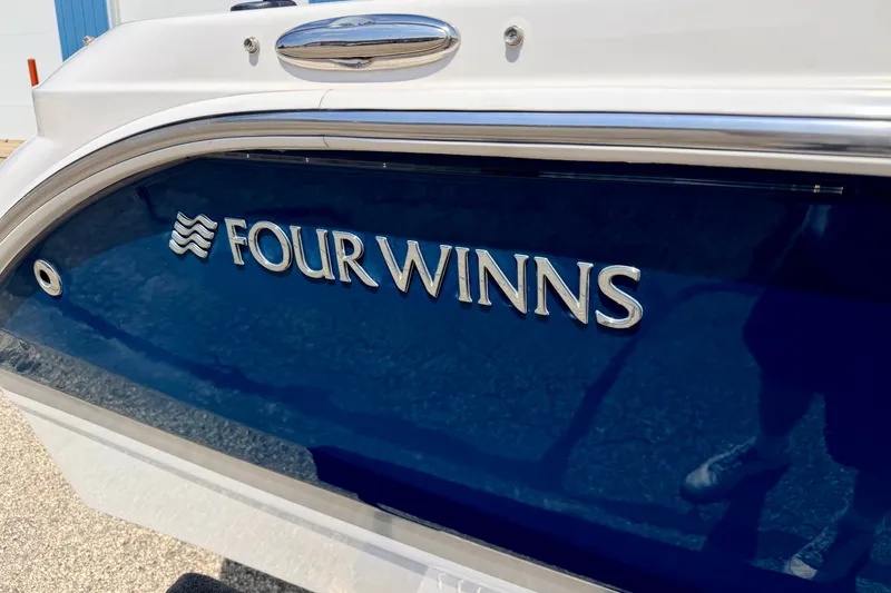 Slide: The Image of 2014 Four Winns H200 boat with blue and white exterior detailing. - 6