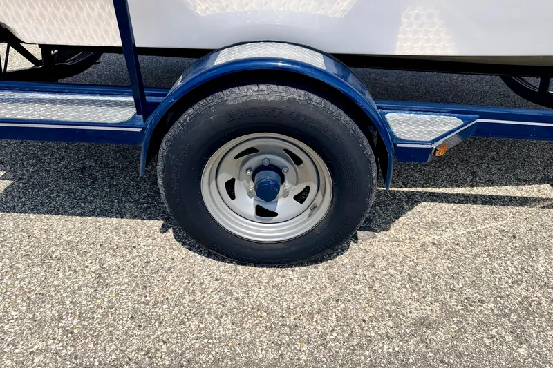 Slide: The Image of Trailer wheel of a 2014 Four Winns H200 boat on asphalt. - 85