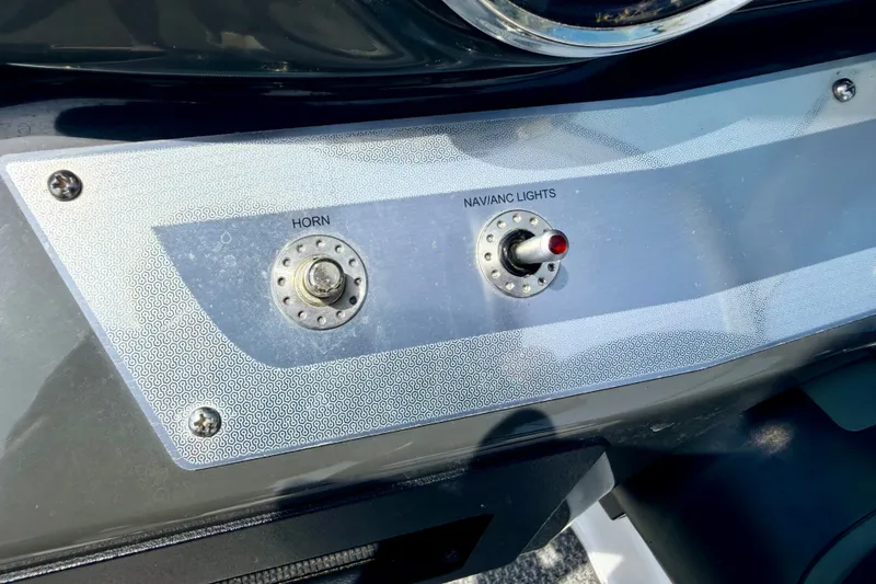 Slide: The Image of Control panel of a 2014 Four Winns H200 boat with horn and navigation lights switches. - 55