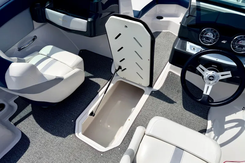Slide: The Image of Interior of 2014 Four Winns H200 boat showing seating, steering wheel, and storage compartment. - 65