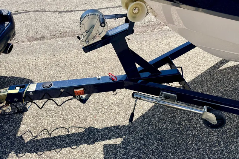Slide: The Image of Trailer hitch and winch of a 2014 Four Winns H200 boat on pavement. - 90