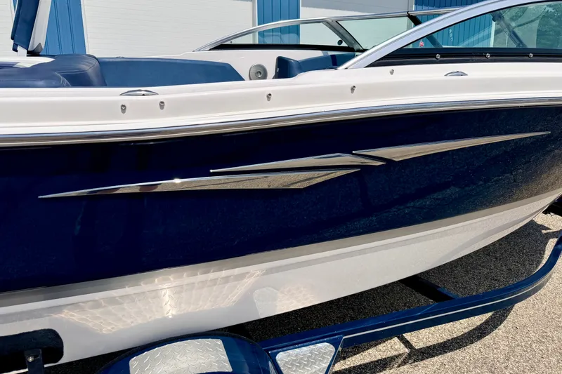 Slide: The Image of 2014 Four Winns H200 boat with sleek blue and white design, docked outdoors. - 7