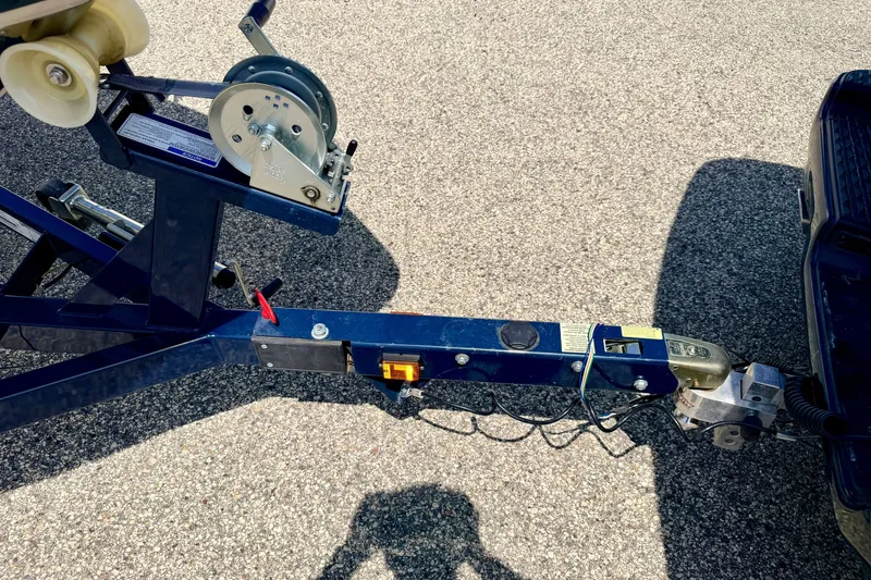 Slide: The Image of Trailer hitch of a 2014 Four Winns H200 boat on asphalt surface. - 82