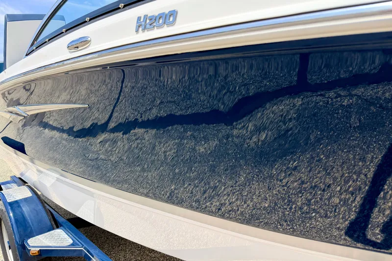 Slide: The Image of 2014 Four Winns H200 boat side view with sleek blue finish on trailer. - 10