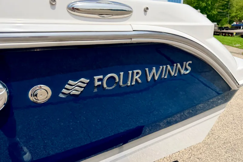 Slide: The Image of 2014 Four Winns H200 boat with blue and white exterior detailing. - 12