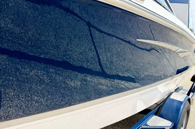 Slide: The Image of 2014 Four Winns H200 boat with sleek blue hull on a trailer. - 14