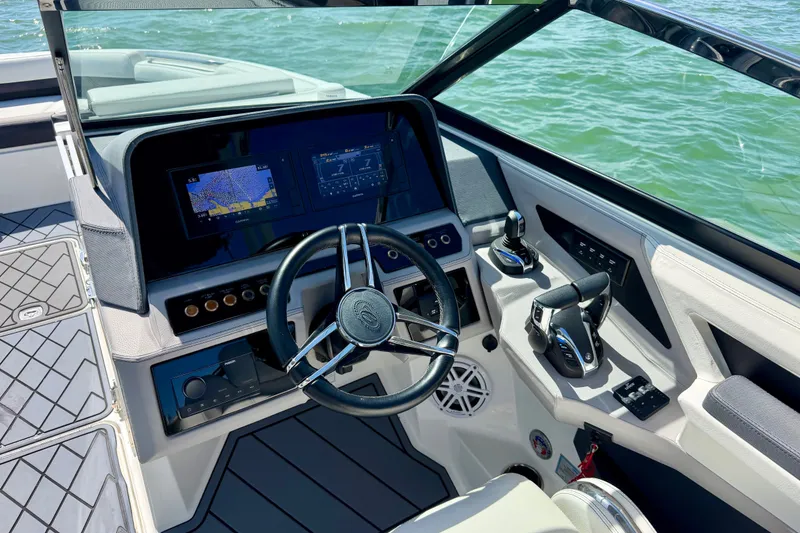 Slide: The Image of 2022 Cobalt R8 Outboard helm with advanced navigation and control systems on open water. - 27