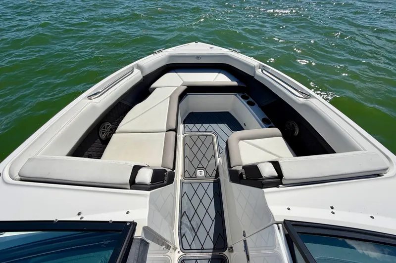 Slide: The Image of 2022 Cobalt R8 Outboard boat interior with cushioned seating on calm water. - 23