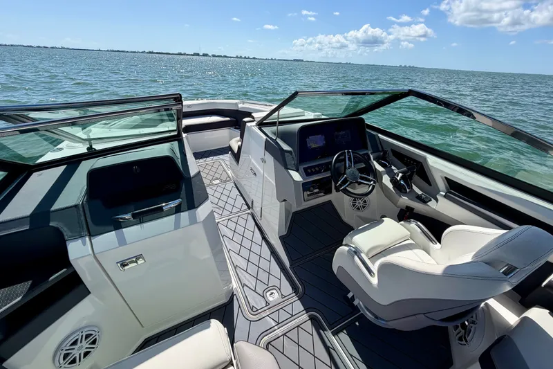 Slide: The Image of 2022 Cobalt R8 Outboard boat interior with steering wheel, dashboard, and seating on open water. - 26