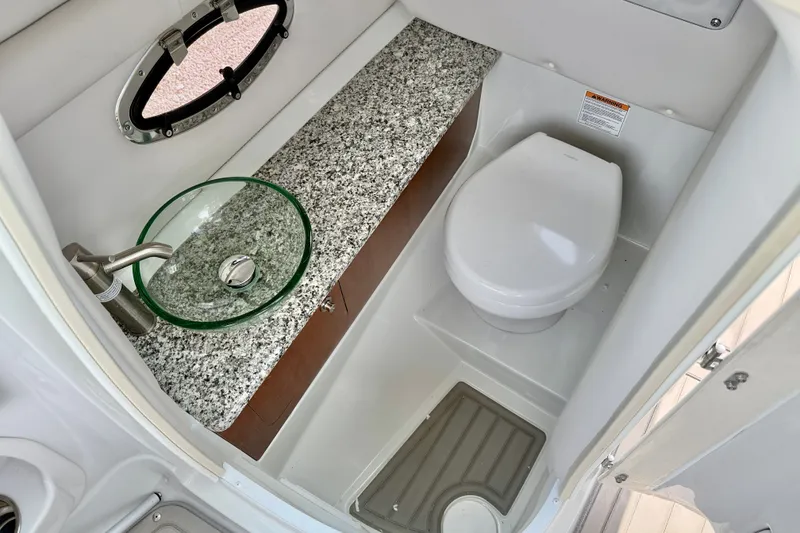Slide: The Image of 2024 Crownline Eclipse E285 XS boat bathroom with granite countertop and modern fixtures. - 19