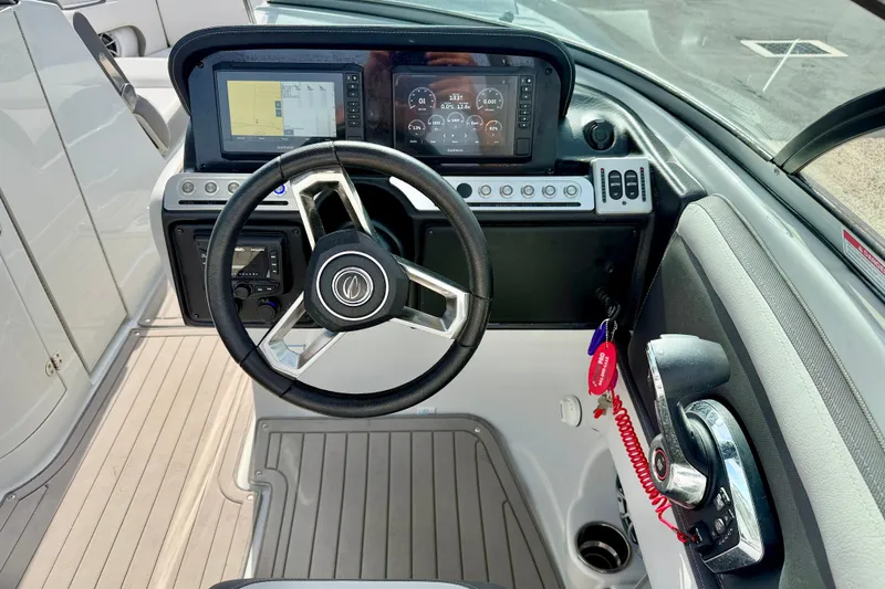 Slide: The Image of 2024 Crownline Eclipse E285 XS boat dashboard with steering wheel and digital displays. - 13