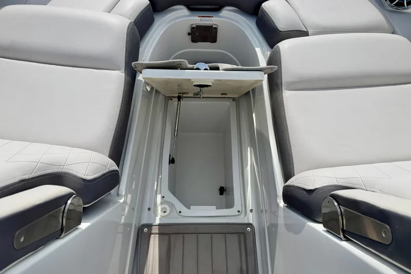 Slide: The Image of 2024 Crownline Eclipse E285 XS boat interior storage compartment with cushioned seating. - 27