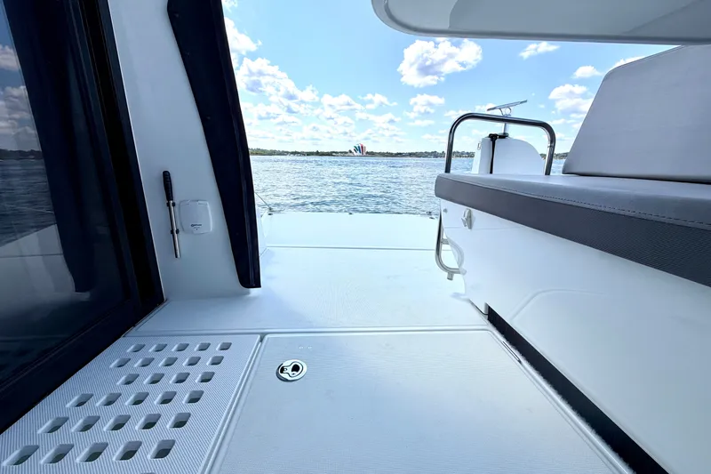 Slide: The Image of 2023 Beneteau Antares 11 OB boat deck with seating, overlooking serene water and sky. - 25