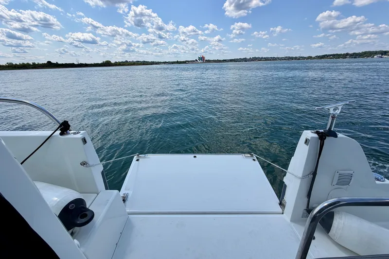 Slide: The Image of 2023 Beneteau Antares 11 OB boat deck overlooking calm water and cloudy sky. - 32