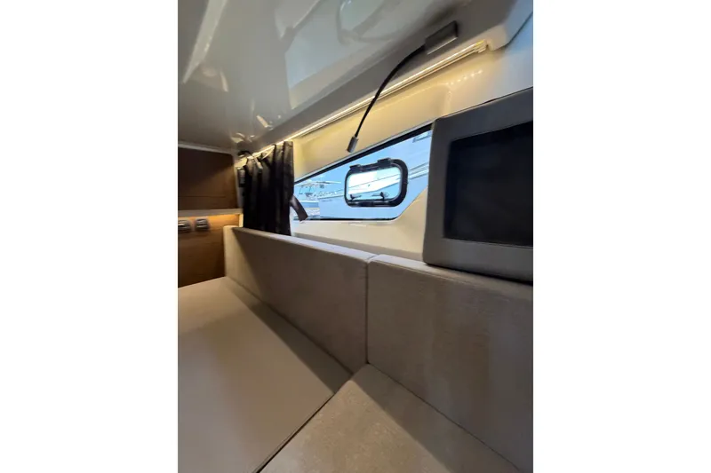 Slide: The Image of Interior of 2023 Beneteau Antares 11 OB, featuring modern seating and window view. - 75