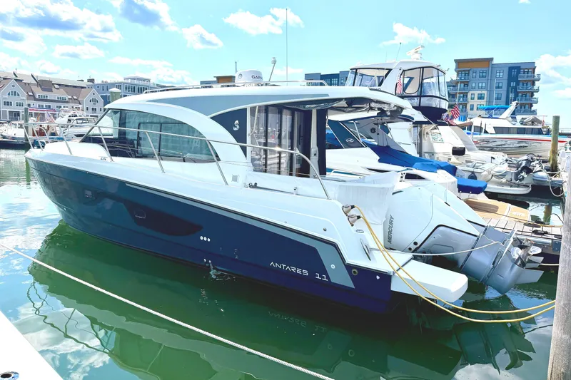 Slide: The Image of 2023 Beneteau Antares 11 OB yacht docked in a marina under a clear blue sky. - 3