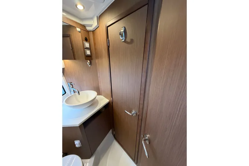 Slide: The Image of Modern bathroom interior of 2023 Beneteau Antares 11 OB boat, featuring sleek wood finish. - 55