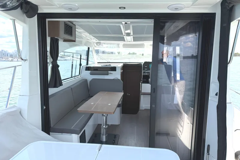 Slide: The Image of Interior view of 2023 Beneteau Antares 11 OB boat, featuring a modern seating area and table. - 20