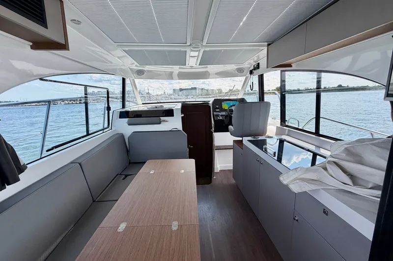 Slide: The Image of Interior of 2023 Beneteau Antares 11 OB yacht with modern seating and panoramic windows. - 30