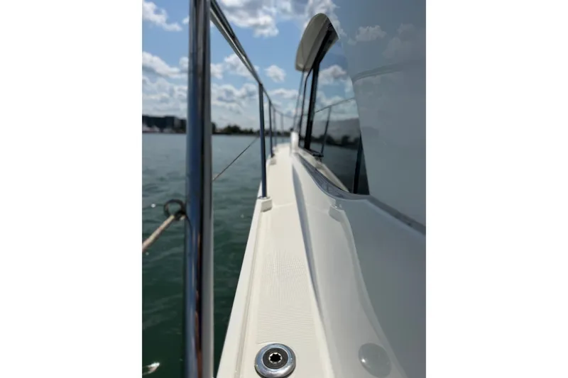 Slide: The Image of 2023 Beneteau Antares 11 OB boat deck with railing, reflecting water and sky. - 12
