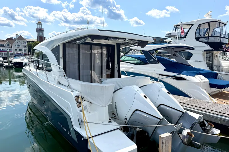 Slide: The Image of 2023 Beneteau Antares 11 OB docked at marina, featuring twin outboard engines. - 10