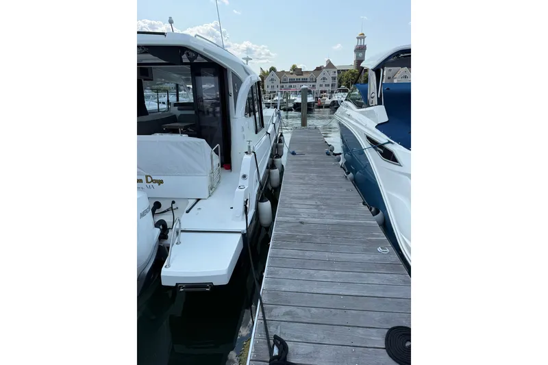 Slide: The Image of 2023 Beneteau Antares 11 OB docked at marina, showcasing sleek design and modern features. - 8