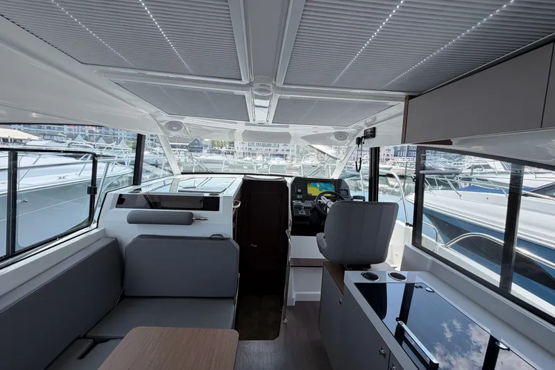 Slide: The Image of Interior of 2023 Beneteau Antares 11 OB boat, featuring modern helm and seating area. - 80