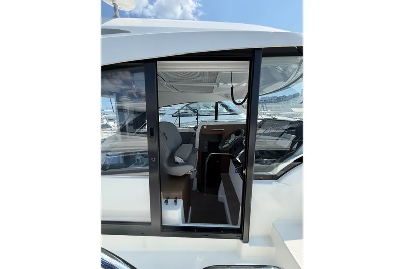 Slide: The Image of 2023 Beneteau Antares 11 OB interior view with helm and seating area. - 21