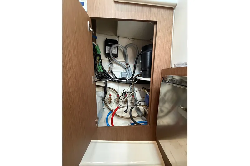 Slide: The Image of Interior view of 2023 Beneteau Antares 11 OB boat's utility compartment with wiring and plumbing. - 65