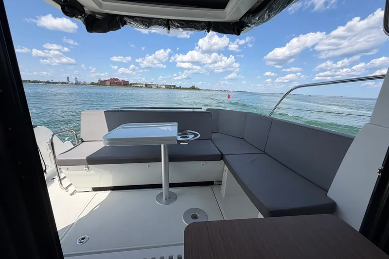 Slide: The Image of 2023 Beneteau Antares 11 OB boat interior with seating and table, overlooking calm waters. - 24