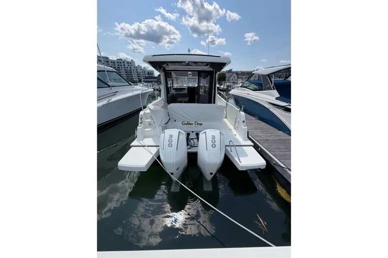 Slide: The Image of 2023 Beneteau Antares 11 OB docked, featuring dual outboard engines under a clear sky. - 98