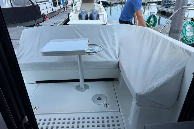 Slide: The Image of 2023 Beneteau Antares 11 OB boat interior with seating and table at dock. - 19