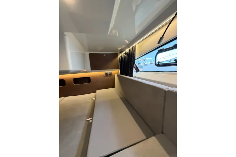 Slide: The Image of Interior of 2023 Beneteau Antares 11 OB, featuring modern seating and window view. - 74