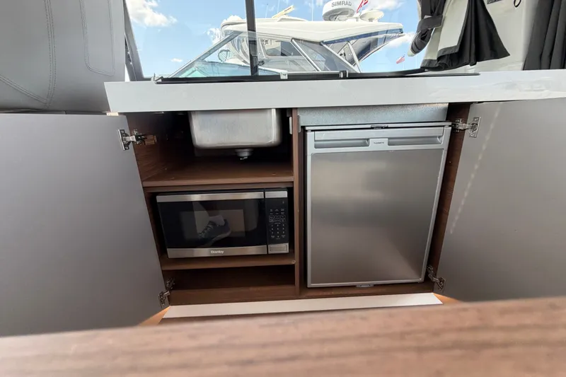 Slide: The Image of 2023 Beneteau Antares 11 OB kitchen with microwave, fridge, and sink. - 84
