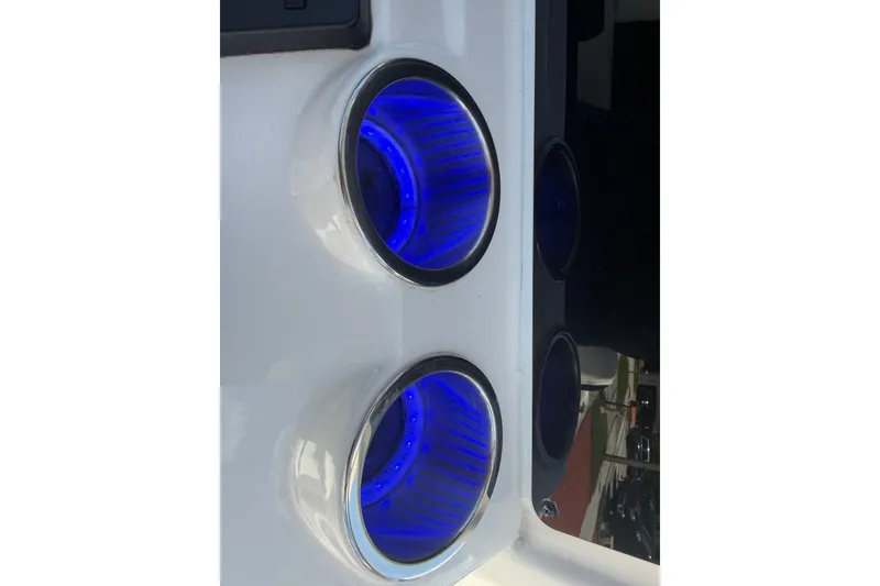 Slide: The Image of Close-up of illuminated blue cup holders on a 2022 Tidewater 2410 Bay Max boat. - 28