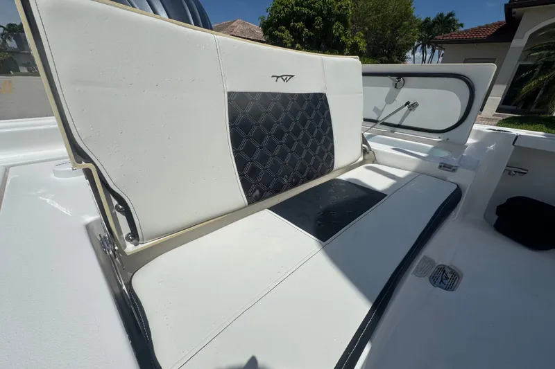Slide: The Image of 2022 Tidewater 2410 Bay Max boat interior with cushioned seating and storage compartment. - 12