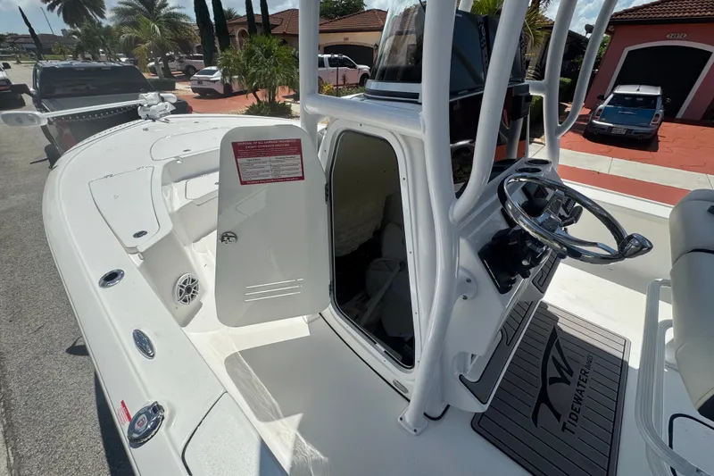 Slide: The Image of 2022 Tidewater 2410 Bay Max boat interior with steering wheel and open storage compartment. - 18