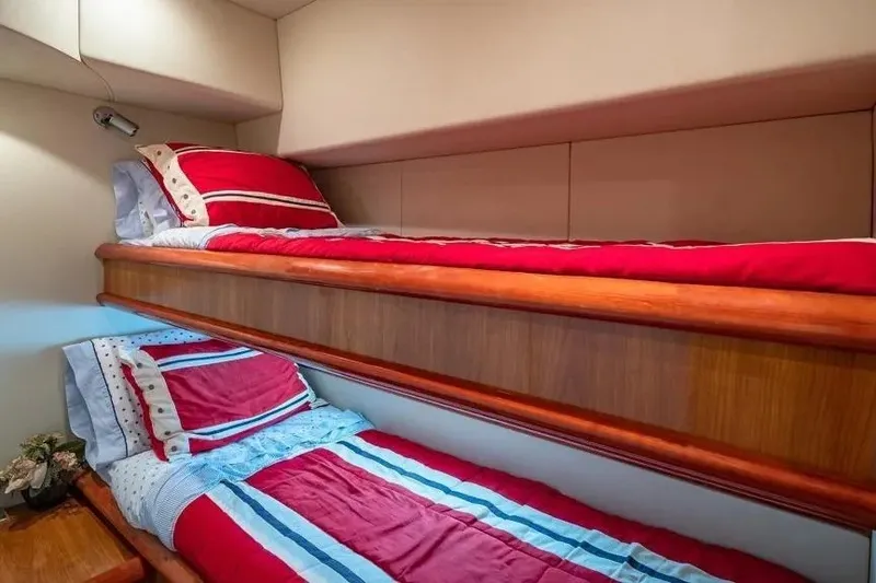 Slide: The Image of Bunk beds with red and blue bedding in a 2000 Sunseeker Manhattan 74 yacht cabin. - 38